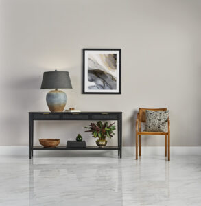 Entryway with polished stone-look tile flooring, a black console table, and framed artwork