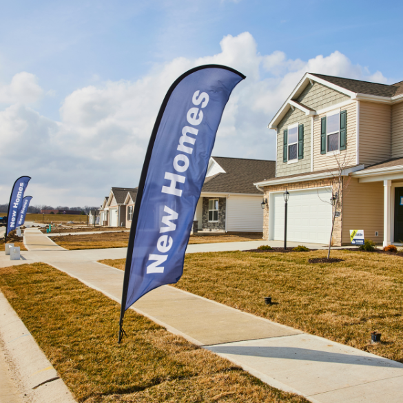 new home sales sign in front of model homes