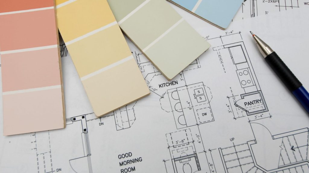 Paint color swatches laid over a kitchen floor plan blueprint